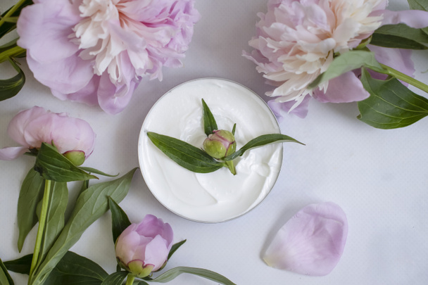 Cream cosmetic flower peony on a light background - Фото, зображення