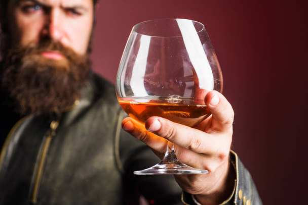 Bir bardak viski ya da brendi ile erkek eli. Alkolik içki. Degukasyon, tatma. Parti, tatil - Fotoğraf, Görsel