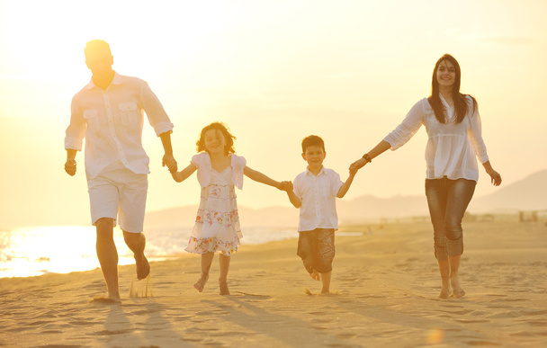 Happy young family have fun on beach at sunset - Фото, зображення