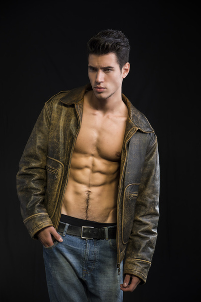 Handsome young man wearing leather jacket on naked torso - 写真・画像