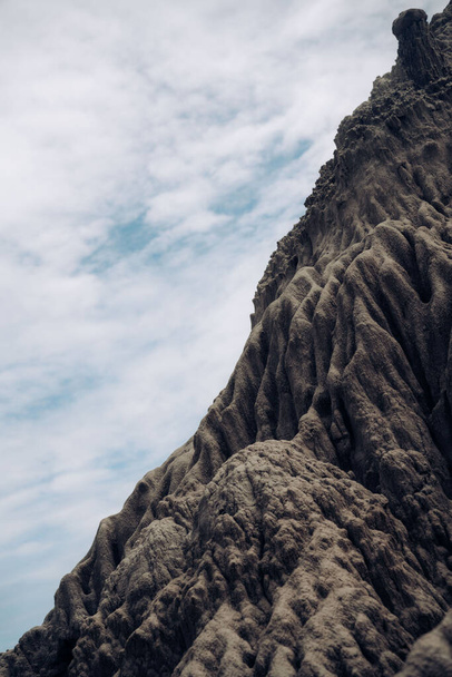 A vertical shot of a big textured rock under the cloudy sky in Colombia - Photo, Image