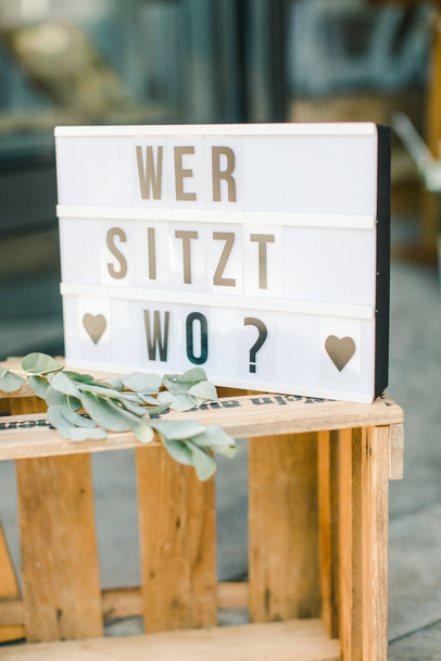 A vertical shot of a seating direction sign in German at a wedding - Photo, Image