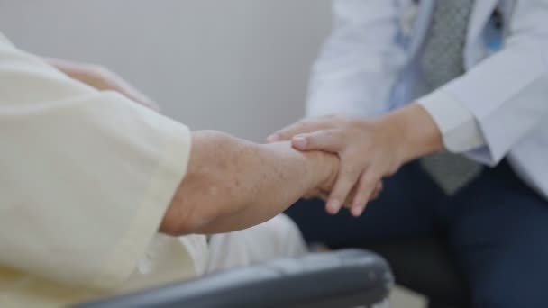 Hand des Arztes tröstet Patientin im Sprechzimmer. Arzt und Patient diskutieren über Diagnose von Symptomen - Filmmaterial, Video