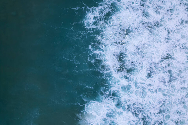 Morze niebieski powierzchnia widok z lotu ptaka. Widok z góry niebieski woda ocean fale z białym tle pianki - Zdjęcie, obraz