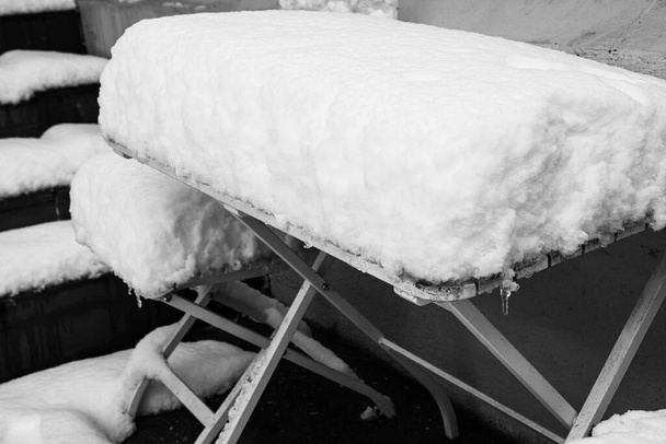 Tökéletes alakú hó az asztalon és székeken, hótakaró. - Fotó, kép
