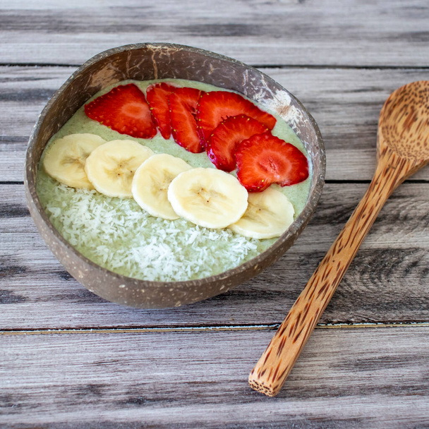 Breakfast smoothie bowl. Raw food diet with wheatgrass, banana and berries - Photo, Image
