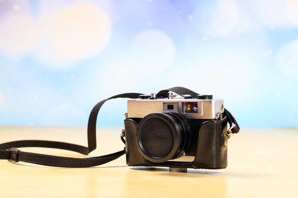 Retro camera op een houten tafel, close-up - Foto, afbeelding