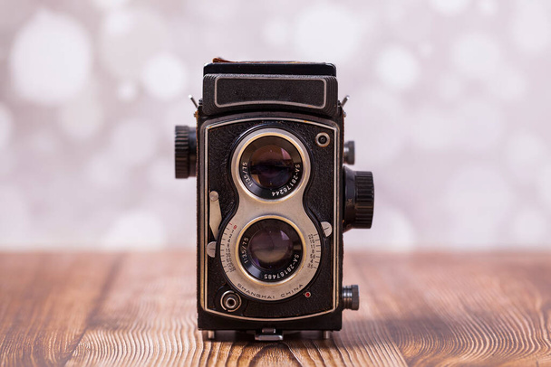 Retro camera op een houten tafel, close-up - Foto, afbeelding