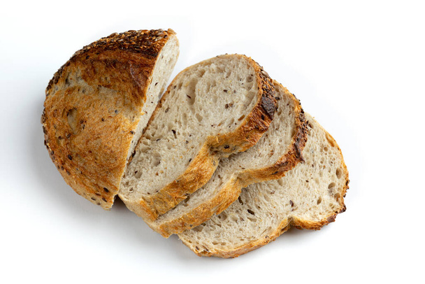 вид сверху на свежий нарезанный домашний хлеб с золотистой хрустящей корочкой на белом фоне, органический хлеб с подсолнухом и льняные семечки крупным планом - Фото, изображение