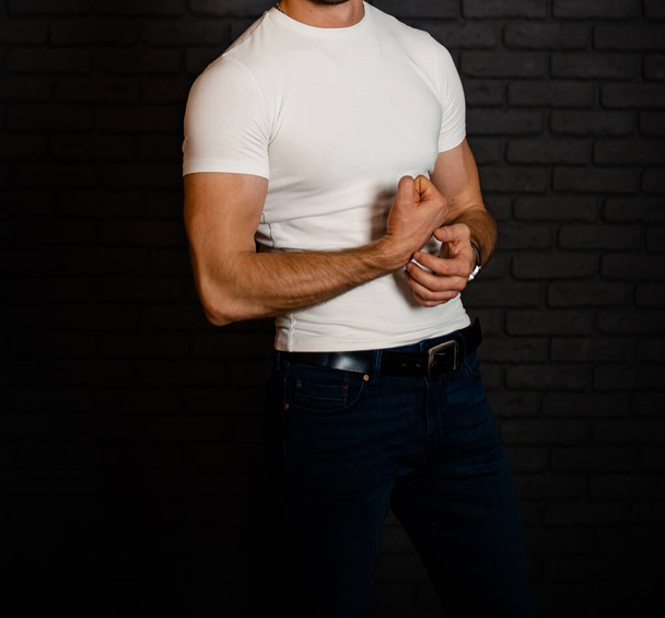Stylish fashionable unrecognizable man in jeans and a white T-shirt. - Fotó, kép