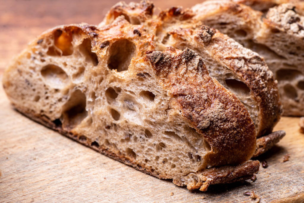 Pieces of buckwheat bread. Sliced baguette on a wooden board. - Foto, Imagen