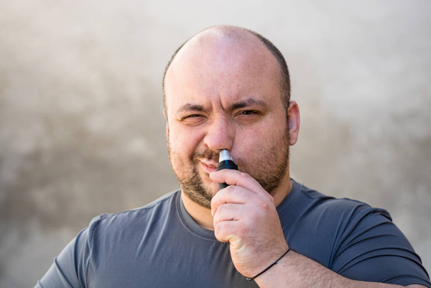 Male shaving ortrimming his nose hair using a hair clipper or electric razor - Photo, Image