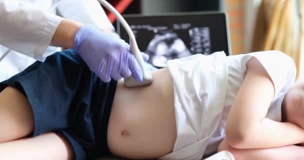 Lääkäri tekee lapsen maksan ultraäänitutkimuksen, lähikuva. Kliininen tutkimus, sairauksien diagnostiikka, pediatria - Materiaali, video
