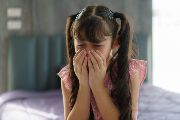 Ασιάτισσα κόρη λυπημένη, προσβεβλημένη, κλαίει στο κρεβάτι στην κρεβατοκάμαρα, έννοια των συναισθημάτων των παιδιών, θλίψη και απογοήτευση - Φωτογραφία, εικόνα