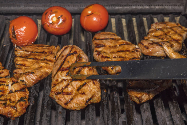 Zblízka pohled na vaření masa steak a rajčata na grilu venku. Švédsko. - Fotografie, Obrázek