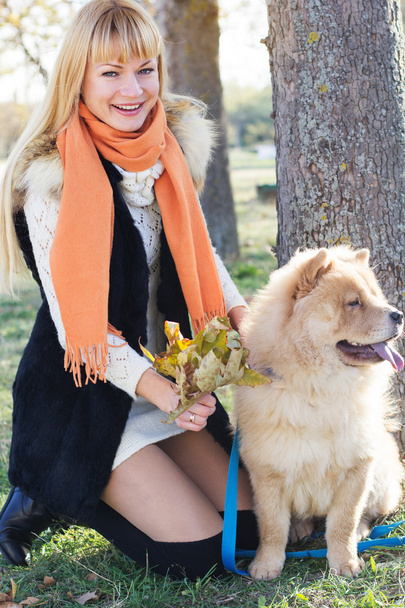 Attractive girl with her dog wearing warm clothes - Photo, Image