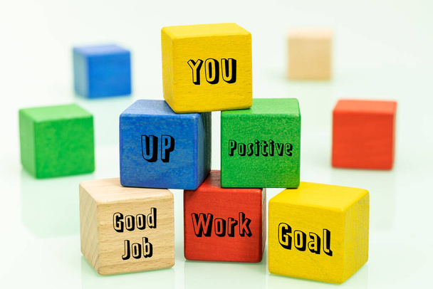 kleurrijke houten blokken met motiverende woorden die zelfontwikkeling stimuleren, het concept van het bouwen van een positief bedrijfsmodel ter ondersteuning van uw eigen ontwikkeling ten behoeve van teamwork - Foto, afbeelding