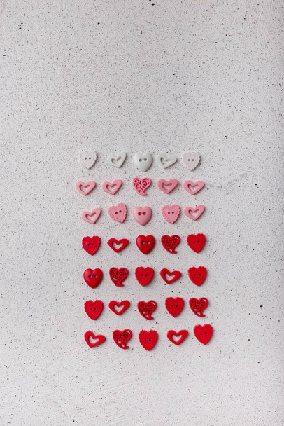 Sada červenobílých ozdobných knoflíků ve tvaru srdce na bílém pozadí. Ozdobné detaily pro šití, scrapbooking, ruční práce - Fotografie, Obrázek