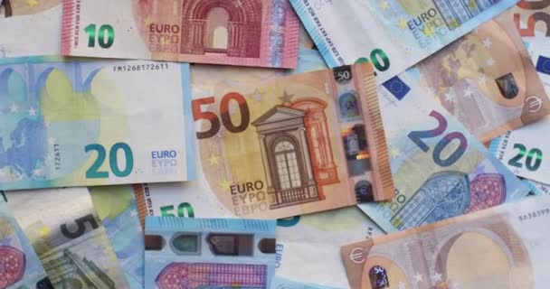 Banknoty euro w różnych nominałach. Stos banknotów na stole w nominałach dwadzieścia euro, pięćdziesiąt euro, dziesięć euro, pięć euro. Kontekst mieszanych banknotów euro - Materiał filmowy, wideo