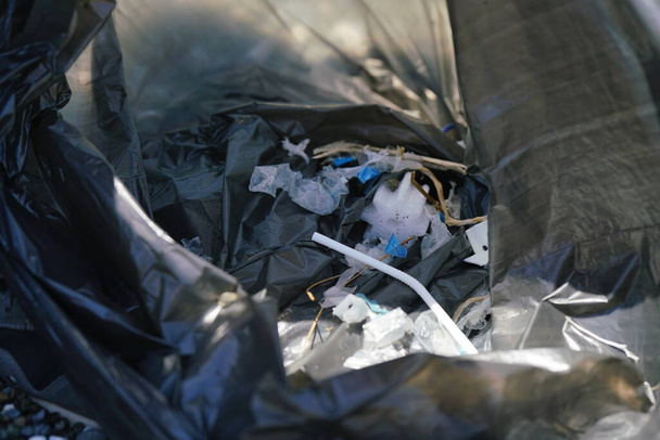 close-up de lixo plástico em um saco de lixo, bebendo palha. Foto de alta qualidade - Foto, Imagem