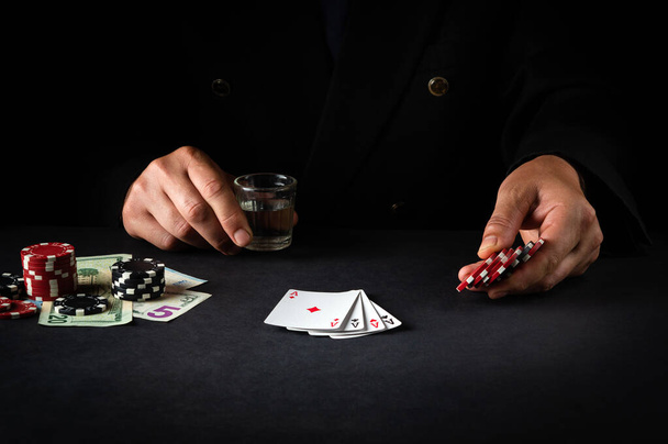 A jogar póquer no clube. Um jogador aposta em uma combinação vencedora com cartas de baralho de quatro de um tipo ou quads em um cassino. - Foto, Imagem