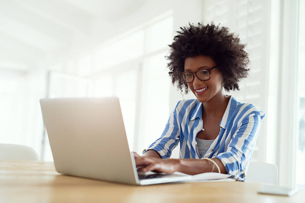 Обрізаний знімок молодої жінки, що працює на ноутбуці вдома
. - Фото, зображення