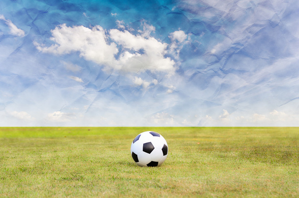 jalkapallo vihreällä ruohokentällä sinisen taivaan alla
 - Valokuva, kuva