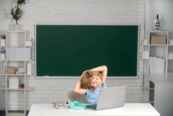 Cute little school kid boy study in a classroom. Portrait of pupil rest and relaxing after school lesson - Foto, imagen