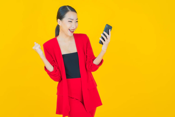 Portrait beautiful young asian woman smile with smart mobile phone on color background - Photo, Image