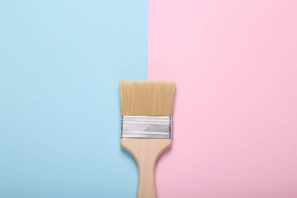 Paint brush with wooden handle on blue pink background - Valokuva, kuva