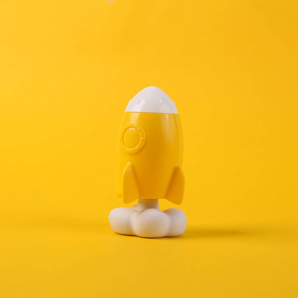 Toy yellow space shuttle or rocket on yellow background. Minimalism, conceptual pop, fresh idea or startup - 写真・画像