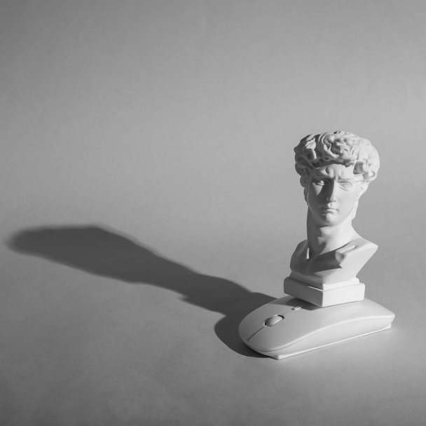 Busto antico di David con moderno mouse pc su sfondo grigio. Natura morta minima - Foto, immagini