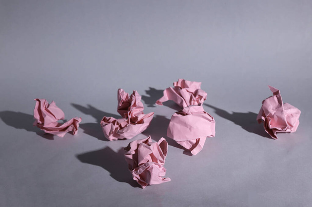 Bolas de papel rosadas enrugadas no fundo cinza com sombra - Foto, Imagem