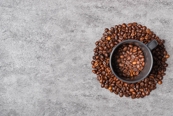 Feijões de café Arabica em uma xícara preta no chão de fundo. - Foto, Imagem