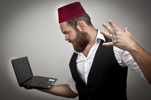 Man in traditional turkish hat and dress kabadayi with laptop - Photo, Image