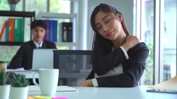 Businesswoman is having office syndrome on shoulder while working in office and rubbing for shoulder. - Footage, Video