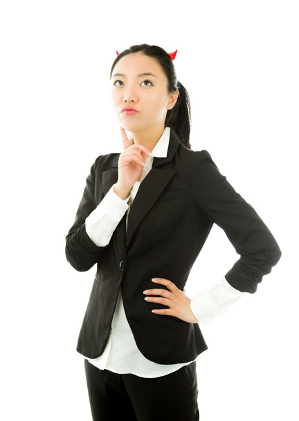 Côté diable d'une jeune femme d'affaires asiatique pensant avec le doigt sur le menton isolé sur fond blanc
 - Photo, image