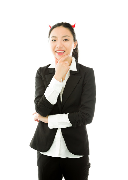 Lado diabólico de una joven empresaria asiática sonriendo con la mano sobre la barbilla aislada sobre fondo blanco
 - Foto, imagen