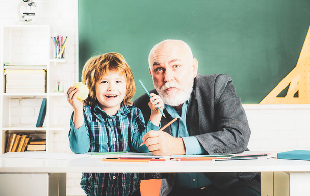 Portrait of happy grandfather and Son in classroom. Grandfather and grandchild - generation people concept. A grandfather and a son are learning in class. Back to school - Φωτογραφία, εικόνα