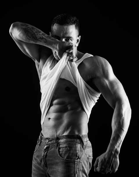 Shirtless athletic naked guy undress. Athletic young man showing his perfect naked body - Valokuva, kuva