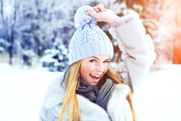 Όμορφη κοπέλα ποζάρει στο χειμερινό πάρκο σε μια ηλιόλουστη ημέρα - Φωτογραφία, εικόνα