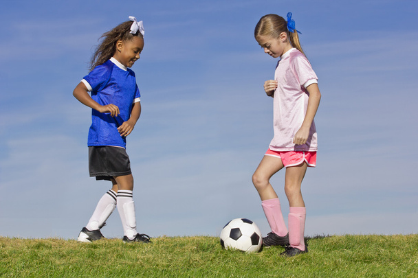 Duas raparigas a jogar futebol
 - Foto, Imagem