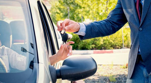Car salesmen send car keys to new owners.Car rental. - Fotó, kép
