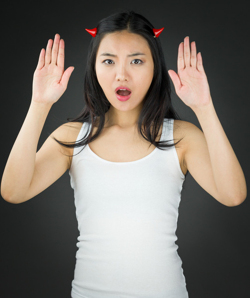 Asyalı genç kadın şeytan yapma dur jest işareti iki eliyle boynuzları - Fotoğraf, Görsel