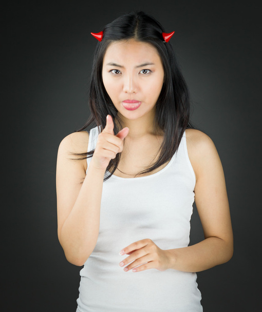 Asiatico giovane donna in diavolo corna attaccare fuori il suo lingua con punta
 - Foto, immagini