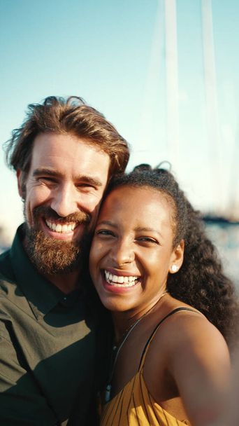 Close up portrait of happy man and smiling woman doing stream on smartphone. Close-up, joyful young interracial couple communicating via video call using mobile phone - Fotografie, Obrázek
