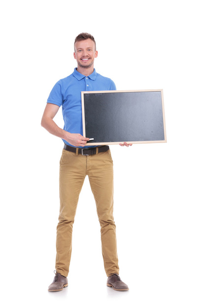 Casual jongeman punten met krijt op blackboard - Foto, afbeelding