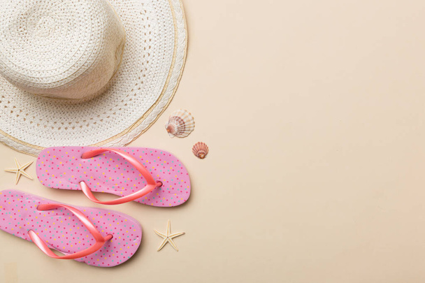 Nyári utazási koncepció. Papucsot, nyári kalapot és tengeri csillagot fehér alapon. Felülnézet színes háttéren. - Fotó, kép