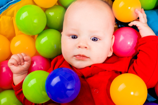 Infant with colorful balls - Foto, afbeelding