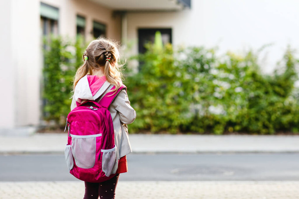 Anaokuluna giden tatlı küçük bir kız. Sağlıklı bir çocuk anaokuluna ve anaokuluna doğru yürüyor. Şehir caddesinde, açık havada sırt çantalı mutlu bir çocuk. - Fotoğraf, Görsel